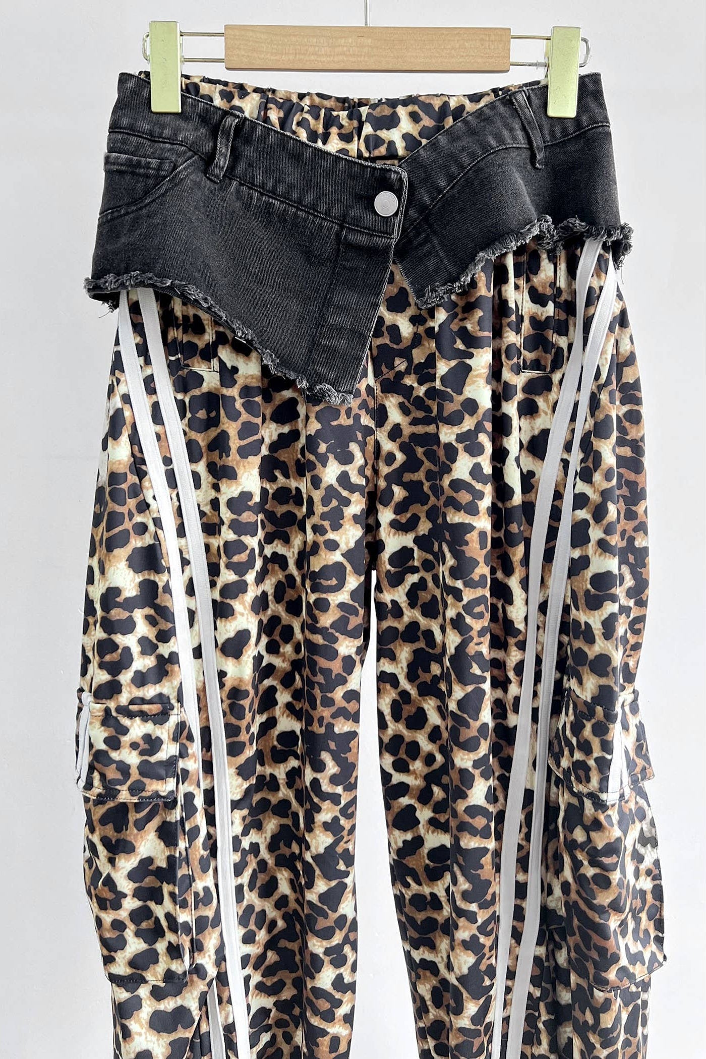 Leopard print pants with black denim waistband on a white background Born To Glam
