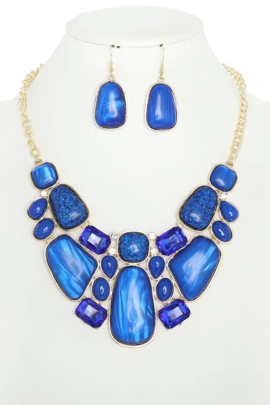 Blue necklace and earrings set on a mannequin with a white background Born To Glam