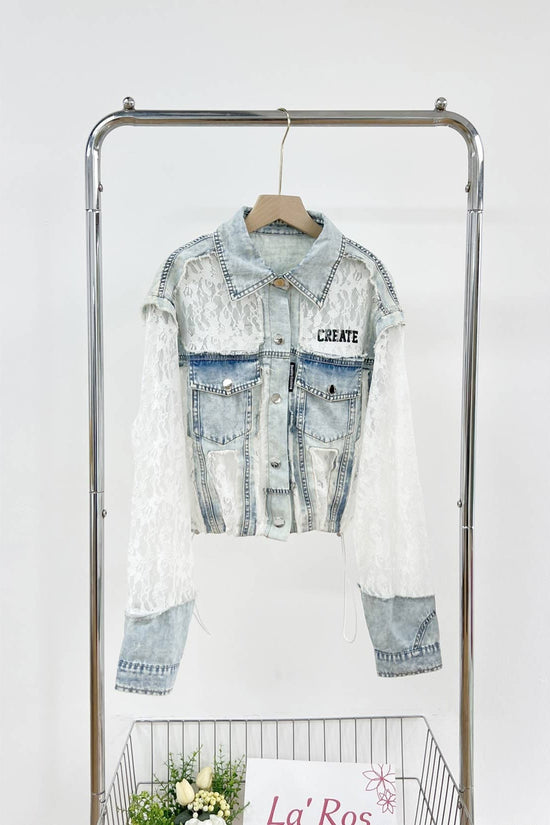 Denim jacket with lace overlay on a clothing rack against a white background Born To Glam