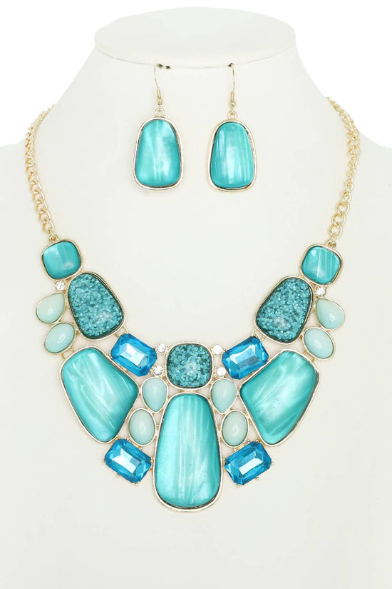 Turquoise necklace and earrings set on a mannequin bust with a white background Born To Glam