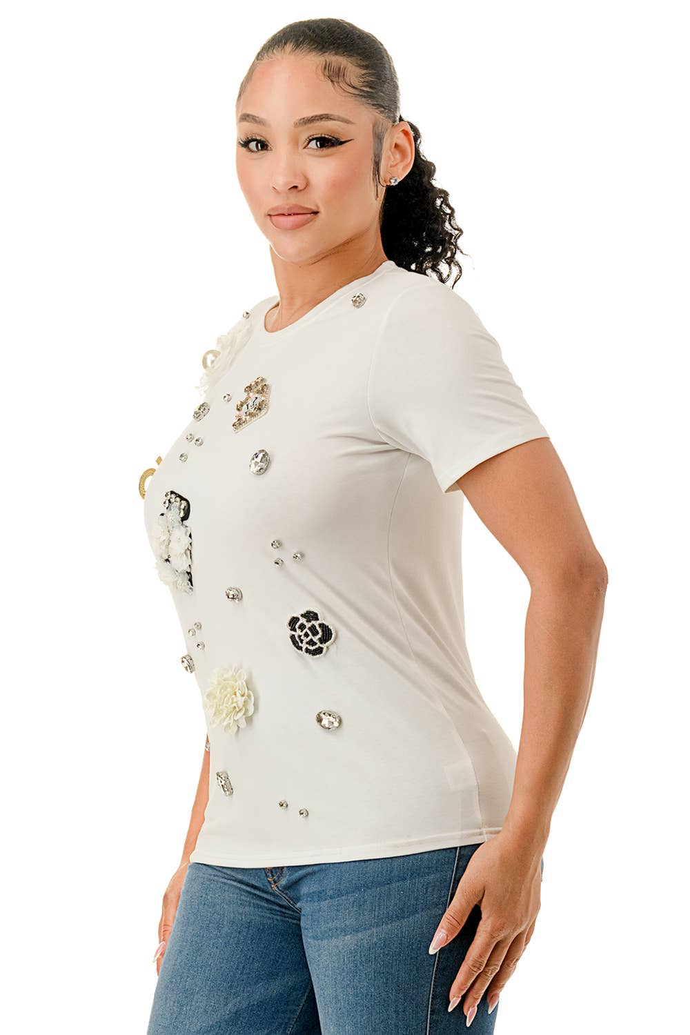 Woman wearing a white t-shirt with decorative buttons and flowers on a white background Born To Glam