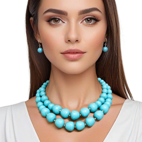 Woman wearing a turquoise necklace and earrings on a white background Born To Glam