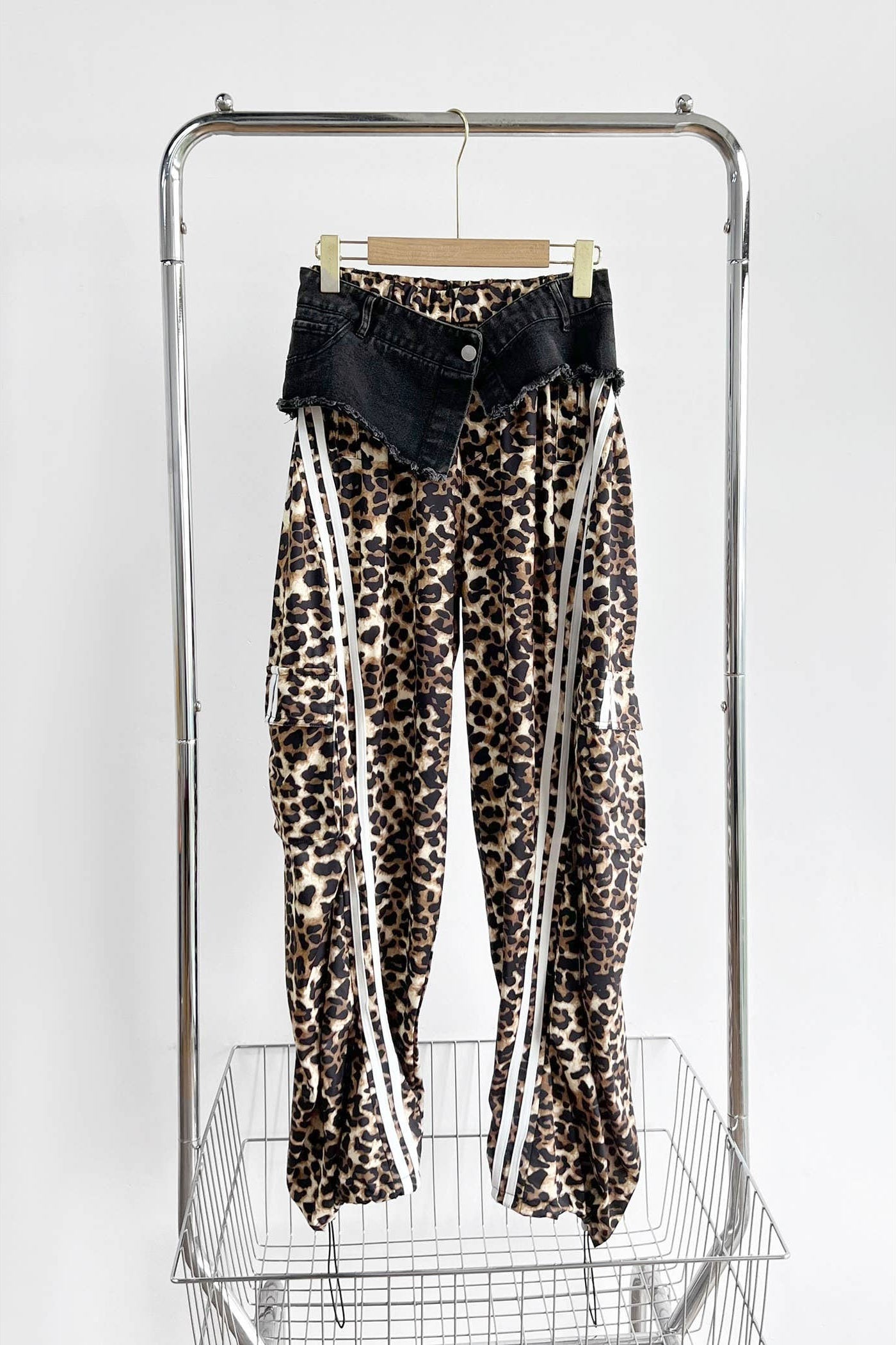 Leopard print pants with white stripes on a rack against a white background Born To Glam