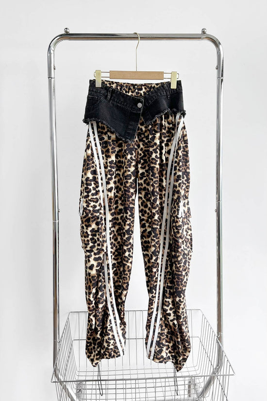 Leopard print pants with white stripes on a rack against a white background Born To Glam