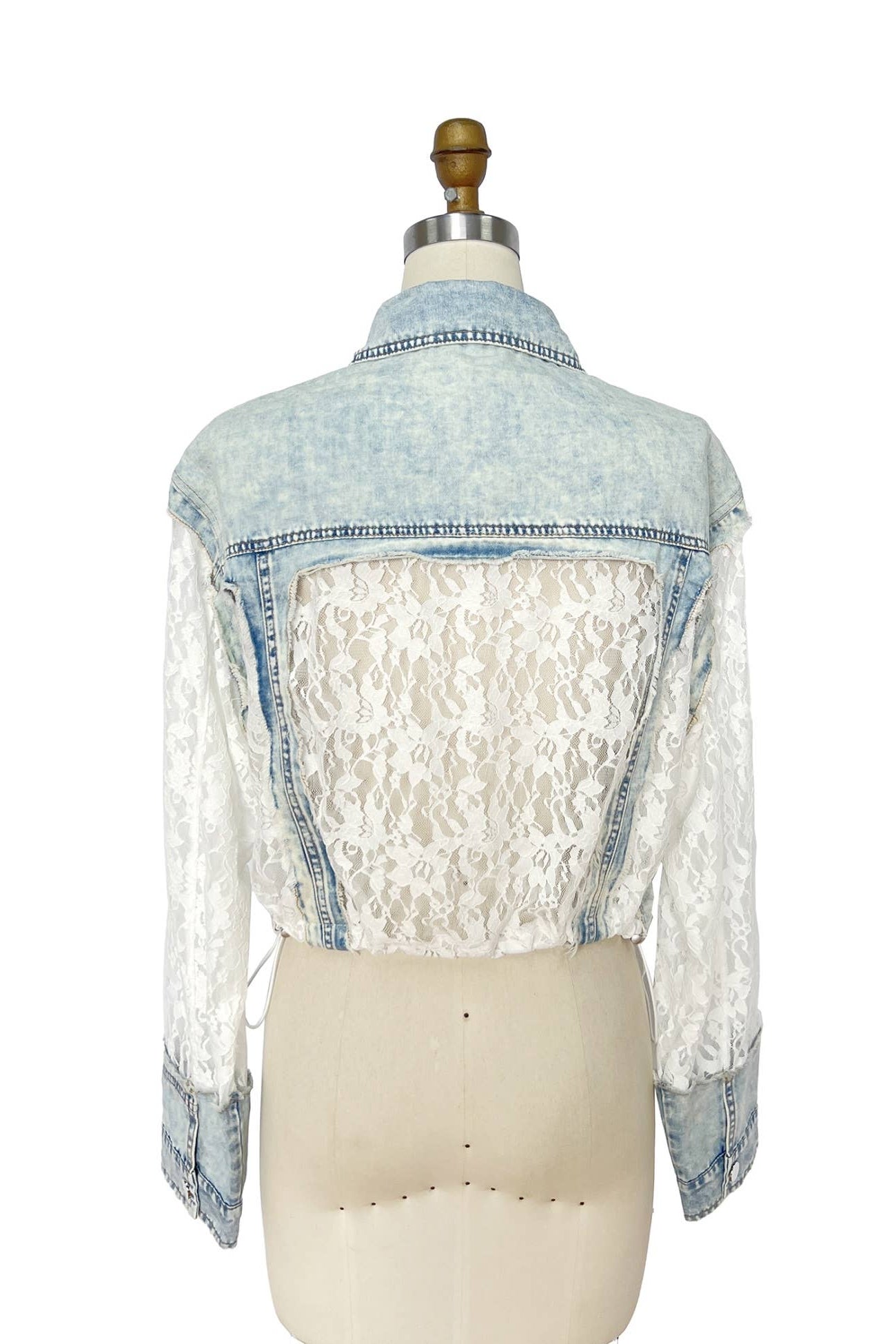 Denim jacket with lace overlay on a mannequin against a white background Born To Glam