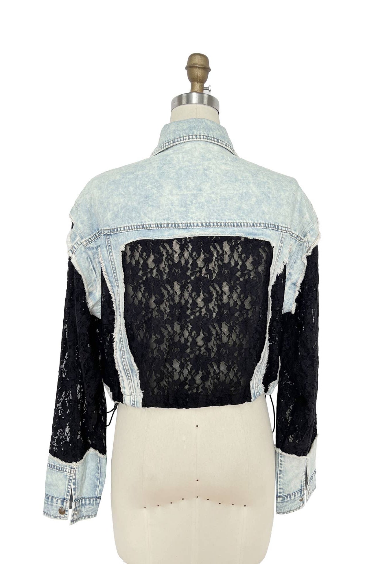 Denim jacket with lace overlay on a mannequin against a white background Born To Glam