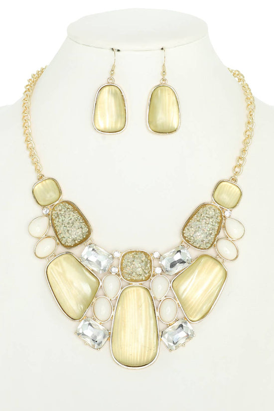 Necklace and earrings set with yellow and gold stones on a mannequin. Born To Glam