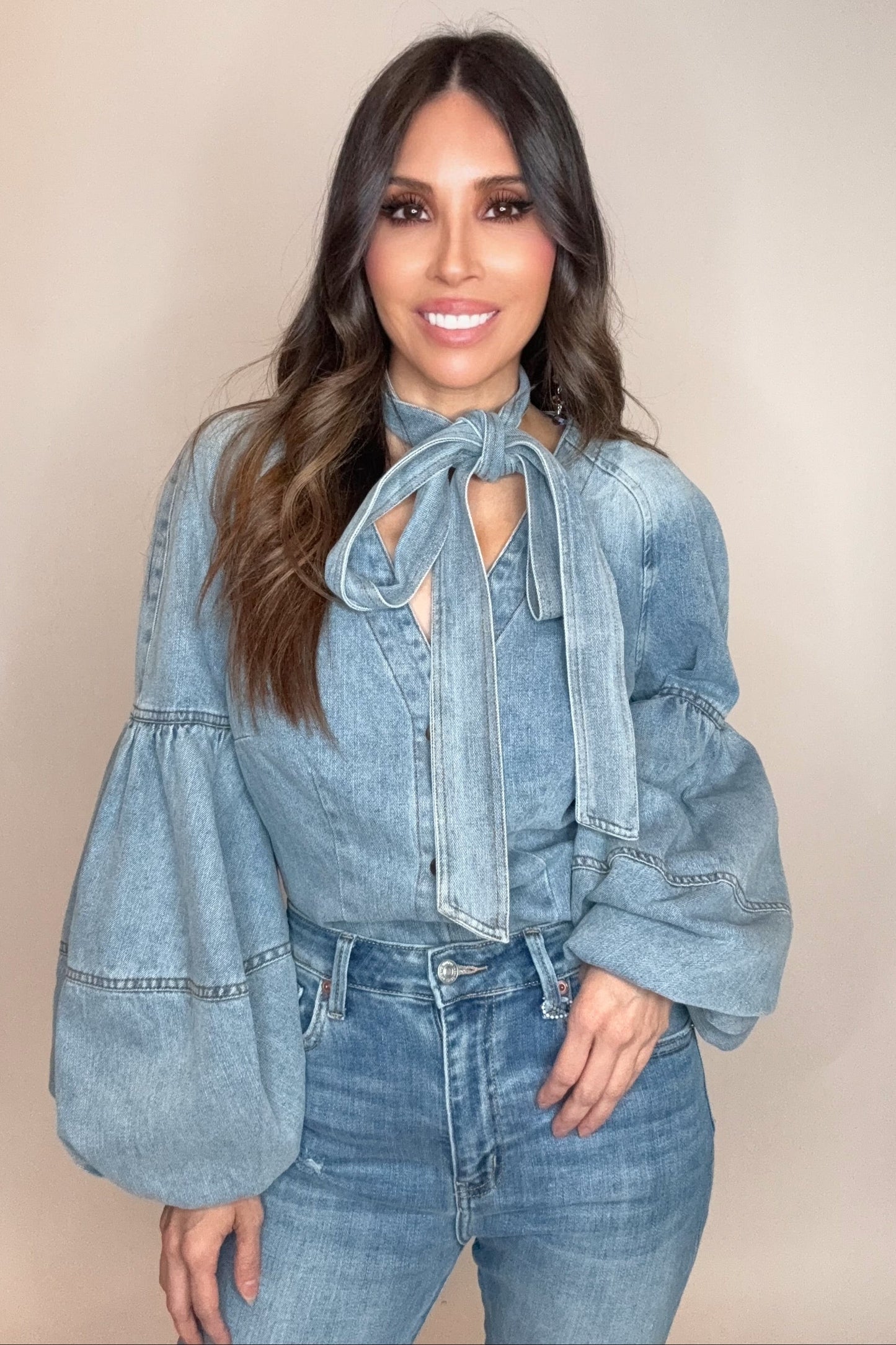 Woman wearing a denim outfit with a beige background Born To Glam