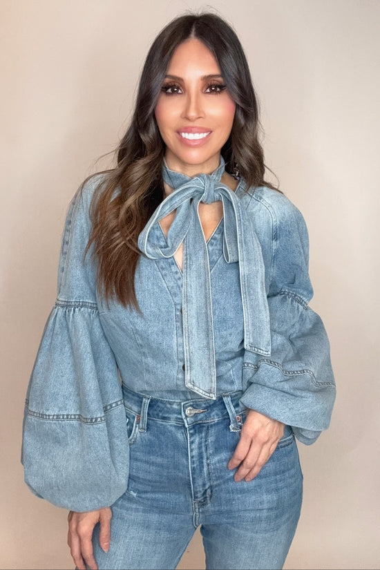 Woman wearing a denim outfit with a beige background Born To Glam