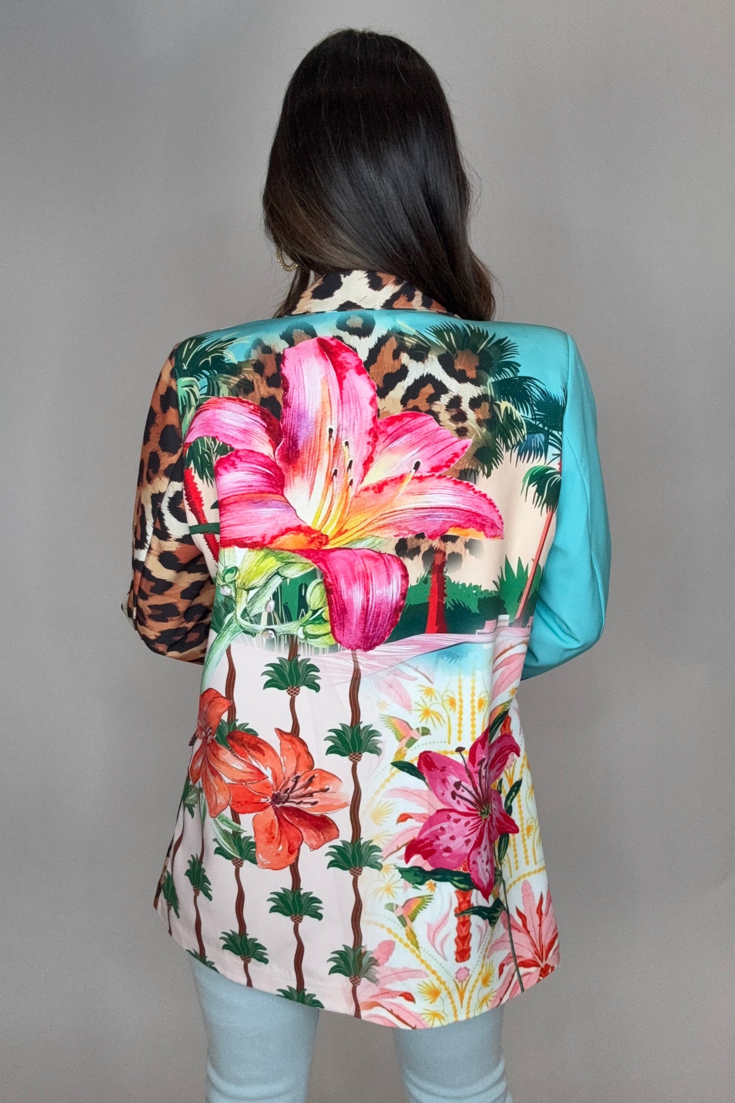 Person wearing a colorful floral and leopard print headscarf on a plain background Born To Glam