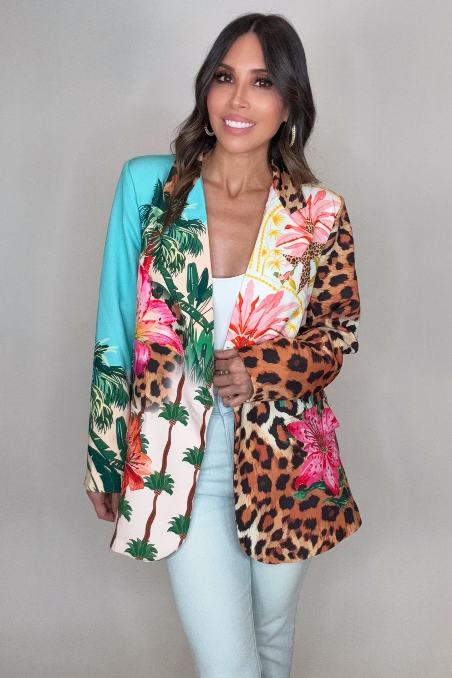 Woman wearing a colorful jacket with floral and leopard print patterns on a plain background Born To Glam