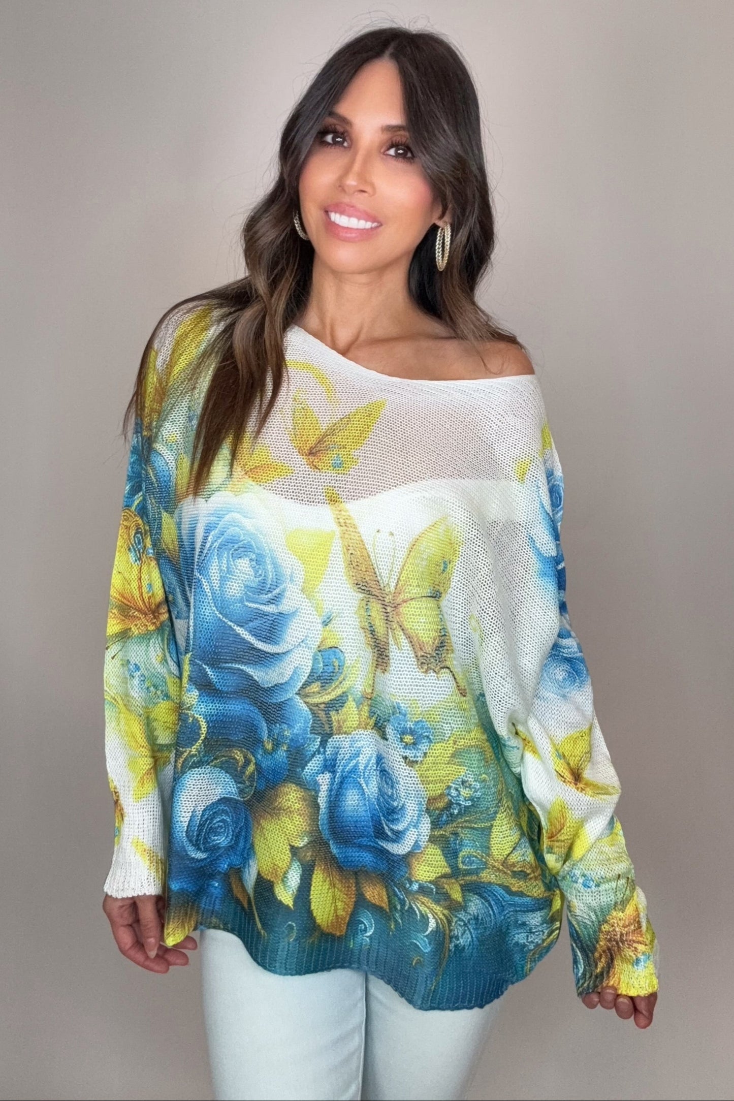 Woman wearing a colorful floral sweater against a plain background Born To Glam