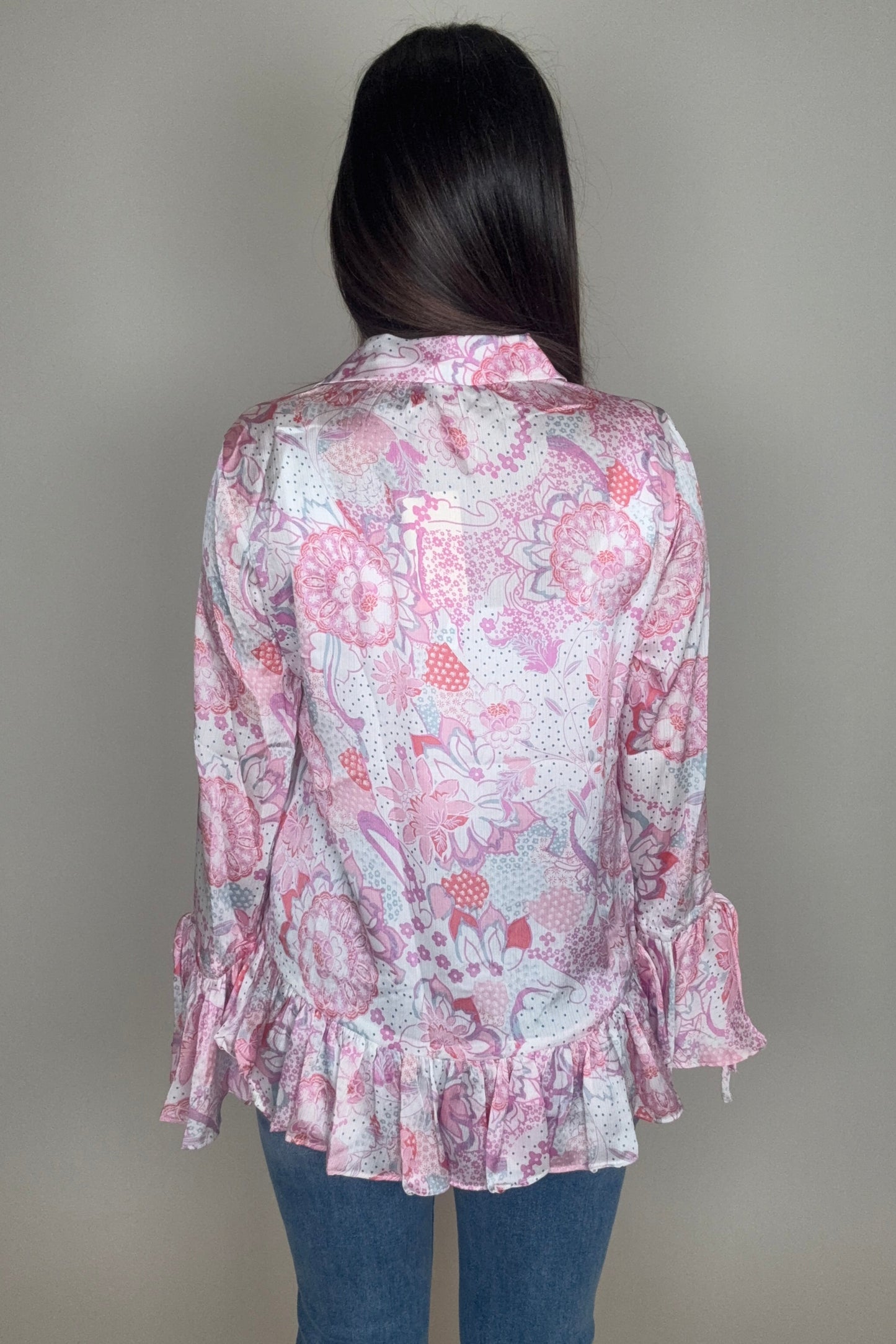 Person wearing a pink floral dress with ruffles on a plain background Born To Glam