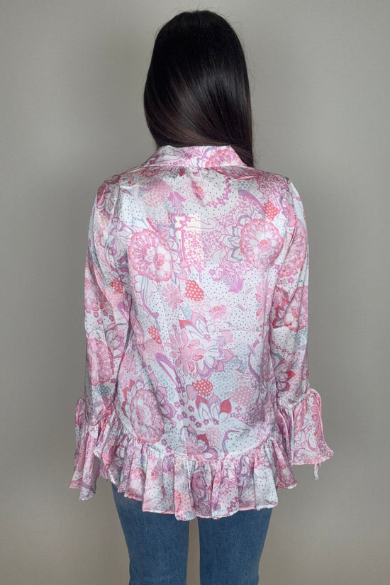 Person wearing a pink floral dress with ruffles on a plain background Born To Glam