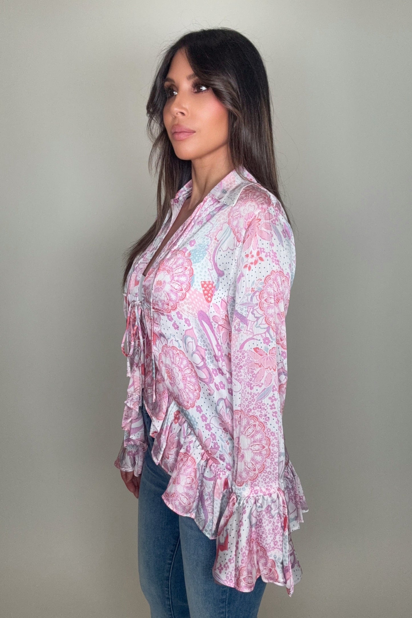 Woman wearing a pink floral blouse against a plain background Born To Glam
