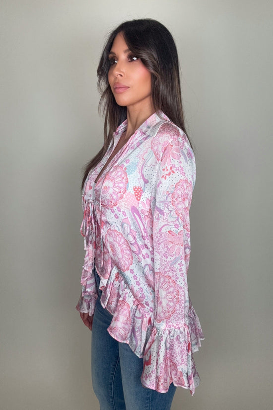 Woman wearing a pink floral blouse against a plain background Born To Glam