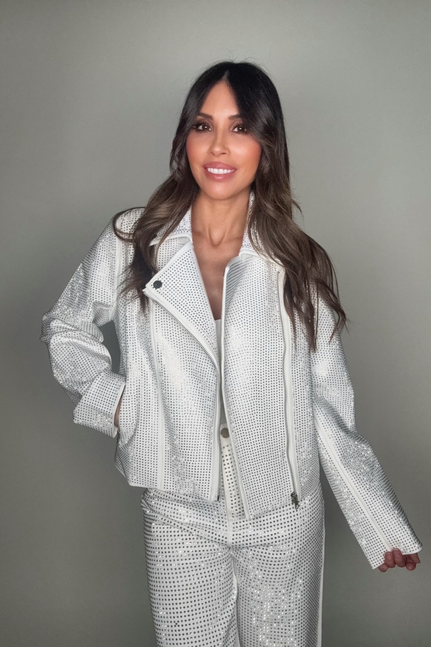 Woman wearing a silver sequin outfit against a gray background Born To Glam