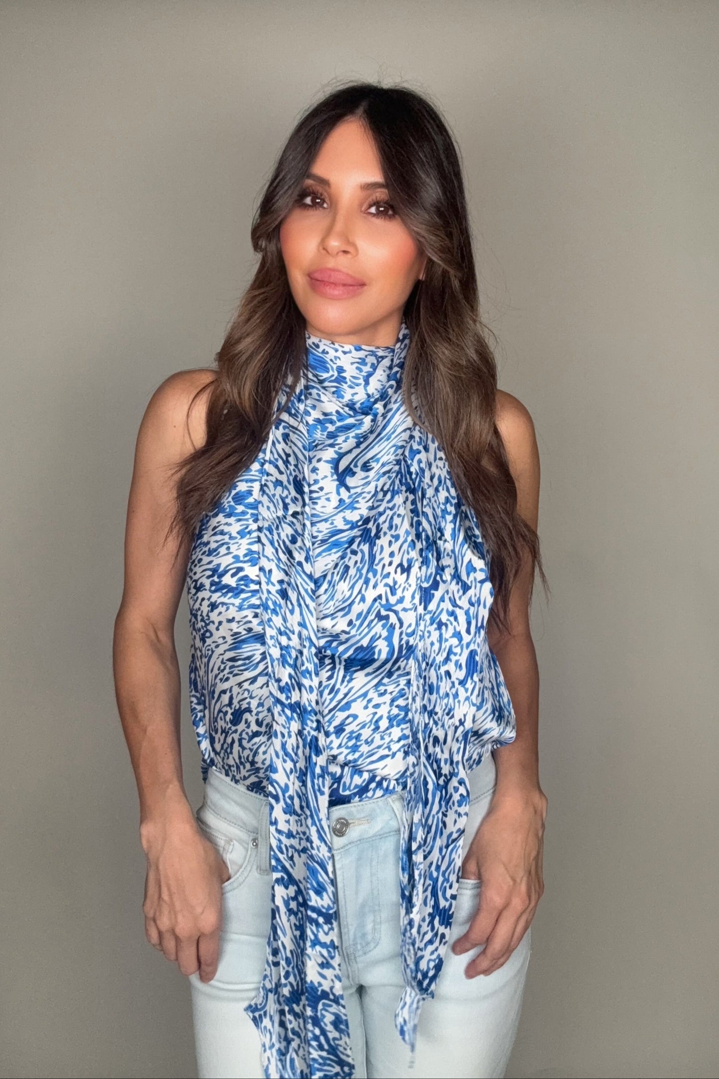 Woman wearing a blue patterned top against a plain background Born To Glam