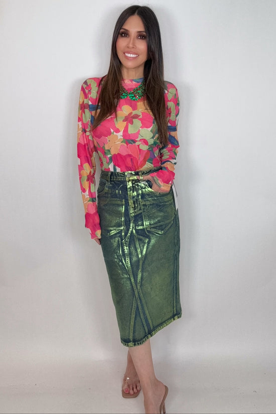 Woman wearing a colorful floral top and green skirt against a white background Born To Glam