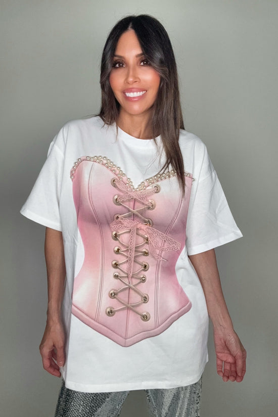 Person wearing a white t-shirt with a pink corset design on a plain background Born To Glam