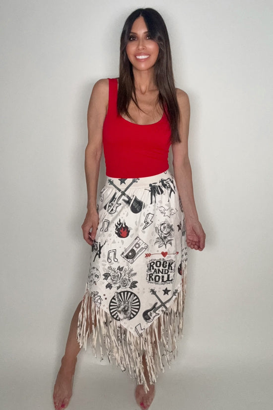 Woman wearing a red top and white skirt with fringe and rock and roll graphics on a plain background Born To Glam