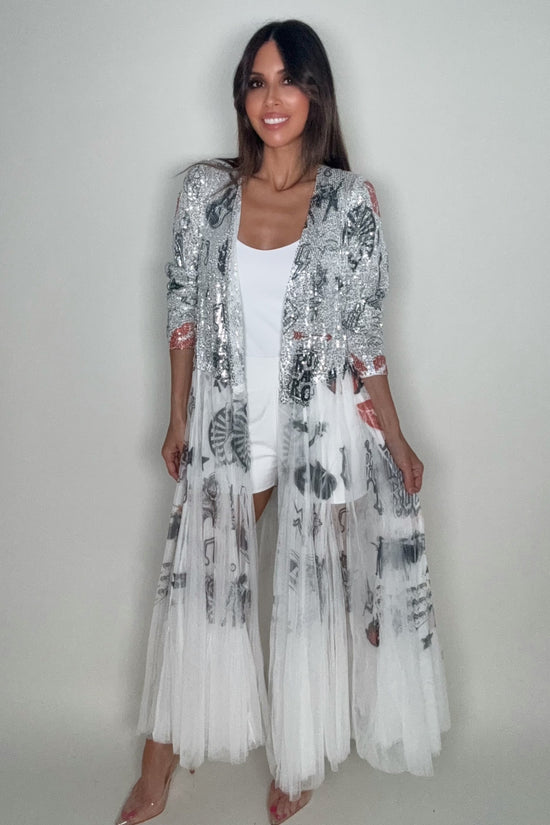 Woman wearing a white and black patterned dress against a plain background Born To Glam