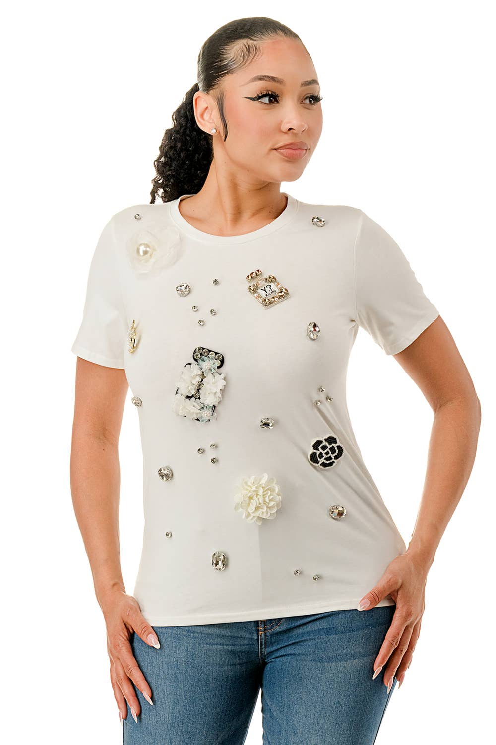 Woman wearing a white blouse with floral embellishments on a white background Born To Glam