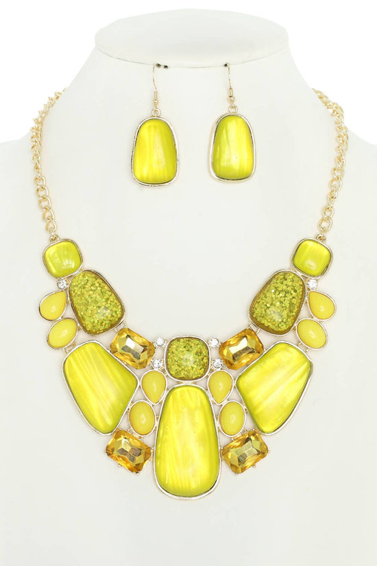 Yellow jewelry set with necklace and earrings on a mannequin bust. Born To Glam