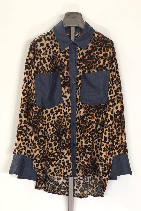 Leopard print shirt with blue accents on a hanger against a white background Born To Glam